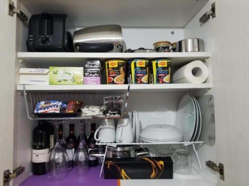 a kitchen shelf with food and drinks in a refrigerator at Schönes Studio direkt am Bodensee in Altenrhein