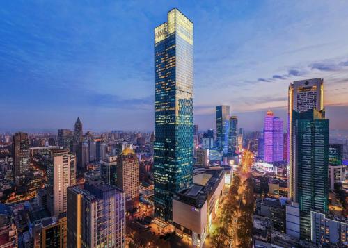 un rascacielos alto en una ciudad por la noche en The Ritz-Carlton, Nanjing en Nankín