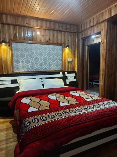 une chambre avec un lit avec une couette rouge dans l'établissement Bitta Inn homestay, à Darjeeling