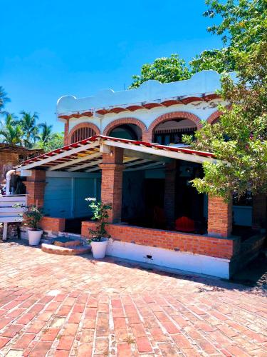 a red brick house with a blue garage at Sayulita Beach House Hotel in Sayulita