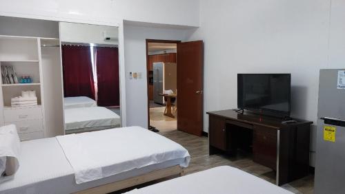 a hotel room with two beds and a television at MANILA BAY EXECUTIVE SUITE pearl of orient in Manila