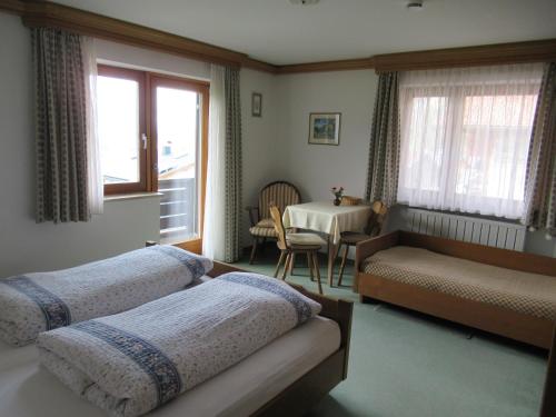 a bedroom with two beds and a table and a window at Haus Elfriede in Reit im Winkl