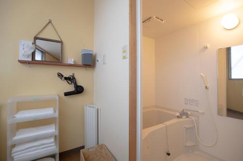 uma casa de banho com uma banheira, um lavatório e um espelho. em Guest House POST INN em Tenkawa
