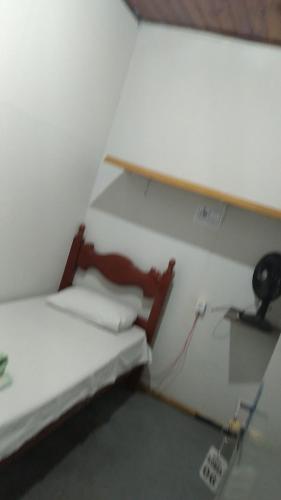 a small room with a bed and a desk at Hostel Gomes in São Paulo