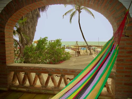 a hammock with a palm tree and a deck at Sayulita Beach House Hotel in Sayulita