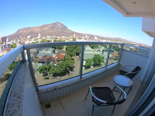 a balcony with two chairs and a view of a city at TH Flats Governador Valadares in Governador Valadares