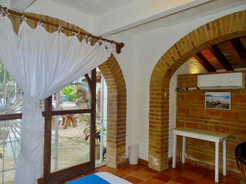 a room with an archway and a table and a window at Sayulita Beach House Hotel in Sayulita