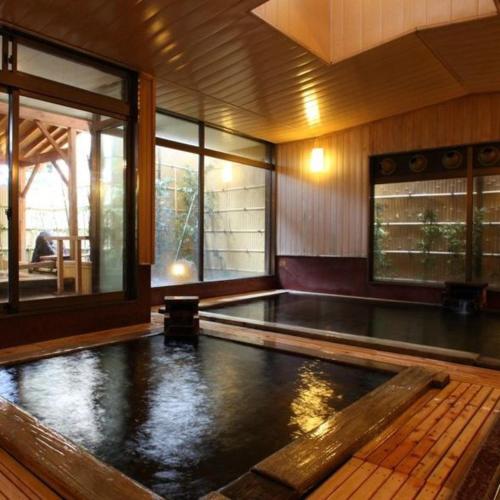 a swimming pool in a house with a pool at Hotel Kameya Honten in Chikuma