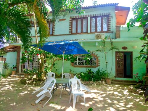 a table and chairs with an umbrella in front of a house at Sayulita Beach House Hotel in Sayulita
