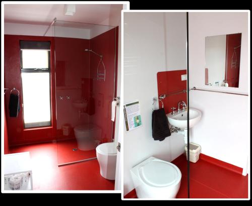 ein rotes Badezimmer mit Toilette und Waschbecken in der Unterkunft Far South Eco-Cabin, Southern Tasmania in Lune River