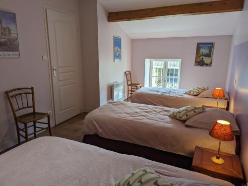 sypialnia z 2 łóżkami i stołem z 2 lampami w obiekcie Maison de Charme avec Jardin, Proche La Rochefoucauld, Wifi, Ping-Pong, et Equipement Bébé - FR-1-653-35 w mieście Bunzac