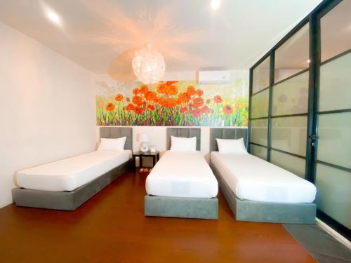 two beds in a room with a painting on the wall at Swiss-Belexpress Rest Area KM. 19 Cikampek in Cikunir Satu