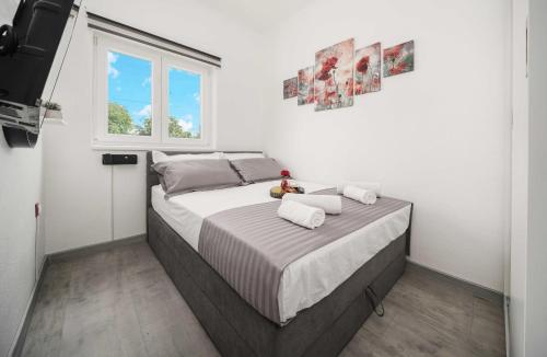 Cama en habitación blanca con ventana en Villa MyDream en Lađevci