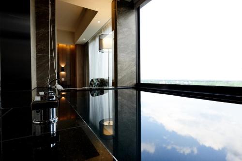 a bathroom with a glass shower with a window at Yamagata Kaku Hotel & Spa in Jiaoxi