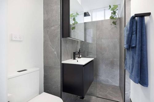 La salle de bains est pourvue de toilettes, d'un lavabo et d'une douche. dans l'établissement Sunny & peaceful apartment in Sydney - Rushcutters bay, à Sydney