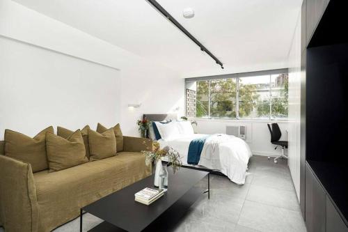 salon z kanapą i łóżkiem w obiekcie Sunny & peaceful apartment in Sydney - Rushcutters bay w mieście Sydney