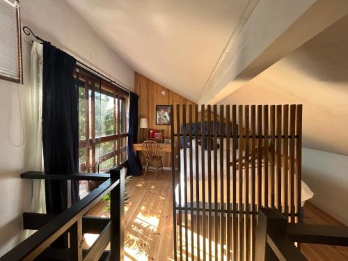 een woonkamer met een groot raam en een stoel bij 4月リニューアルOpen! 全室エアコン完備! Cottage あかいやねｰ The Red Roof Cottage YamanakaKoｰ in Yamanakako