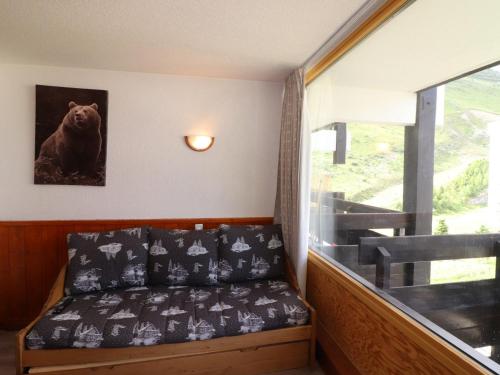 Cette chambre dispose d'un canapé avec une photo d'ours sur le mur. dans l'établissement Studio lumineux avec balcon, proche pistes et commerces, 4 couchages, animaux acceptés - FR-1-502-515, à Tignes