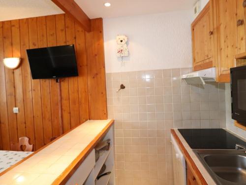 Il comprend une cuisine avec un évier et une télévision murale. dans l'établissement Studio lumineux avec balcon, proche pistes et commerces, 4 couchages, animaux acceptés - FR-1-502-515, à Tignes