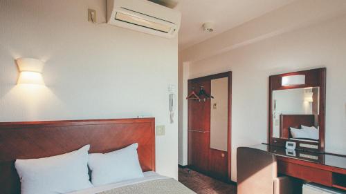 a hotel room with a bed and a mirror at Kuretake-Inn Fujisan in Fuji