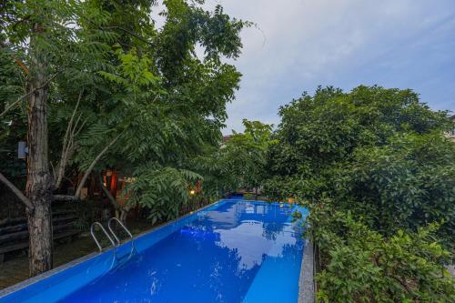 a blue swimming pool with trees in the background at 张家界天门山伴田居民宿 in Zhangjiajie