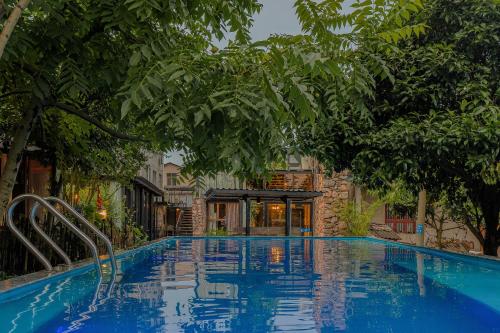 a swimming pool with trees around it at 张家界天门山伴田居民宿 in Zhangjiajie