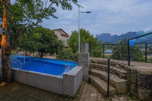 a swimming pool in a house with mountains in the background at 张家界天门山伴田居民宿 in Zhangjiajie