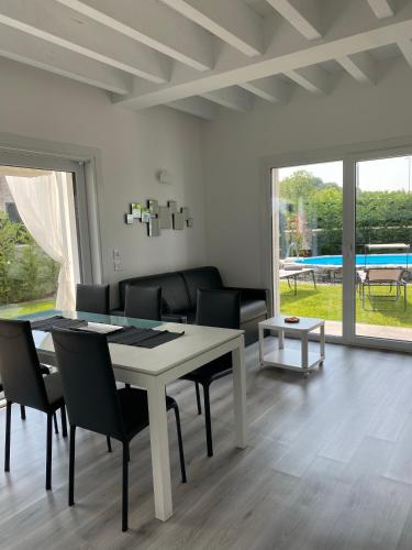 a dining room with a table and chairs and a couch at Villa Carlotta in Salionze