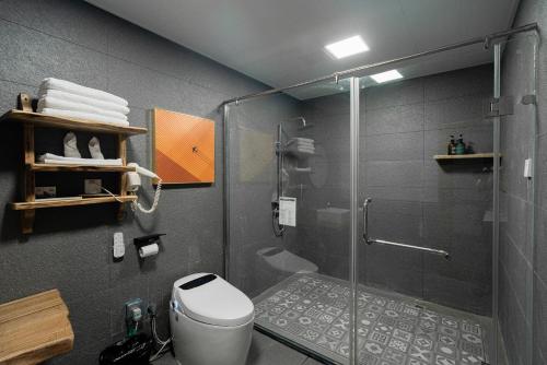 a bathroom with a glass shower with a toilet at 张家界天门山伴田居民宿 in Zhangjiajie