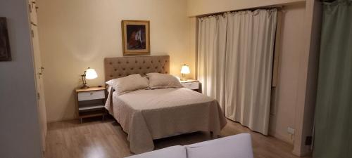 a bedroom with a bed and two night stands with lamps at ApartFlorida3 in Buenos Aires