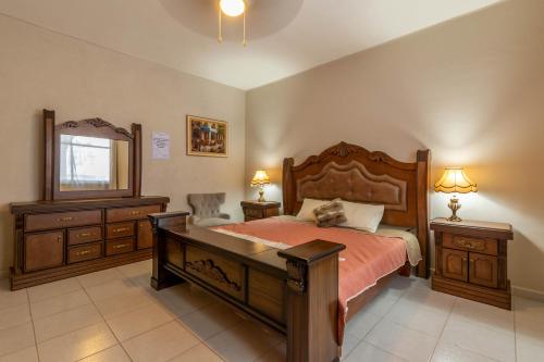a bedroom with a bed with a desk and a mirror at Hostería Casa Marquez in León
