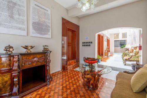 sala de estar con chimenea y mesa de cristal en Hostería Casa Miranda Marquez en León