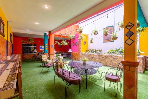 a restaurant with purple tables and chairs in a room at Hostería Casa Marquez in León