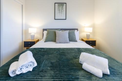 una camera da letto con un grande letto con asciugamani di 1 bedroom 1 bath, Executive escape, Northlands Mall a Christchurch
