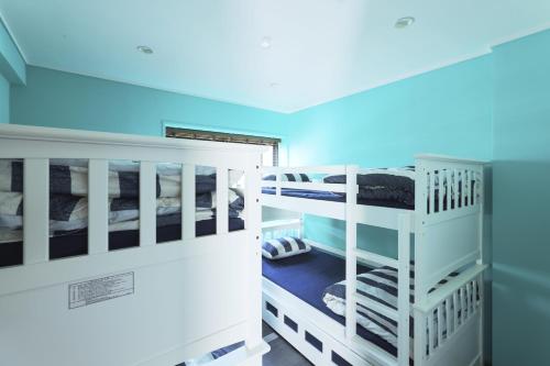 two bunk beds in a room with blue lights at 葉山THE TERRACE HOUSE in Hayama