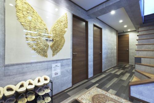a elevator lobby with a large gold butterfly on the wall at 葉山THE TERRACE HOUSE in Hayama