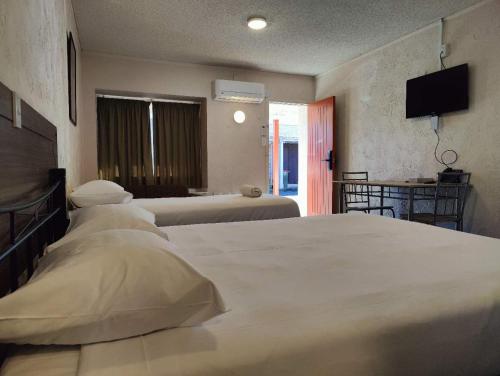 a hotel room with two beds and a television at Kings Court Motor Lodge in Hamilton