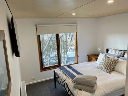 a bedroom with a large bed and a window at Rainbow B in Falls Creek