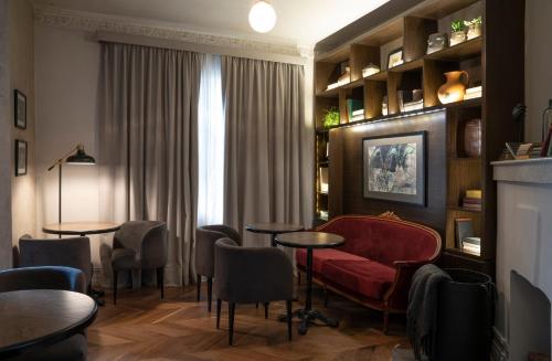 a living room with a red couch and chairs at Aposento Boutique Hotel in Mexico City