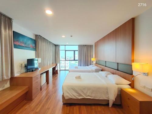 a hotel room with two beds and a television at Ebina House - SHA Extra Plus in Bangkok