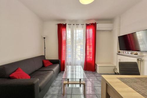- un salon avec un canapé et des rideaux rouges dans l'établissement Luminous cocoon near the beach, à Saint-Raphaël