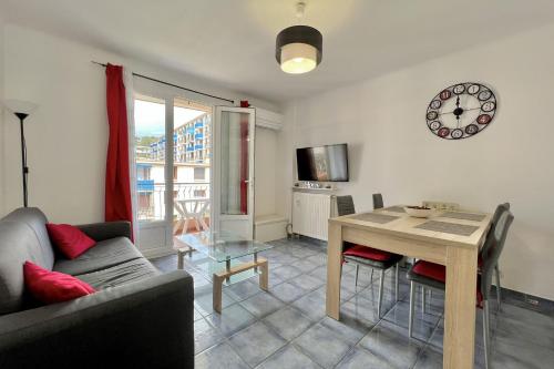 - un salon avec un canapé, une table et un réveil dans l'établissement Luminous cocoon near the beach, à Saint-Raphaël