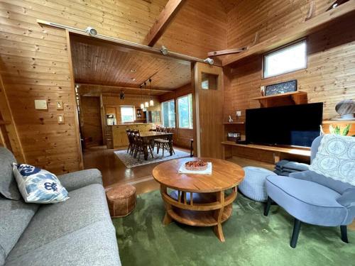 sala de estar con sofá y mesa en 4月リニューアルOpen! 全室エアコン完備! Deerview Lodge 山中湖, en Yamanakako