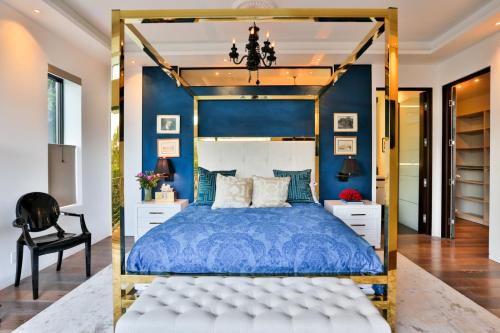 Dormitorio azul con cama y silla negra en Hollywood Hills Sanctuary, en Los Ángeles
