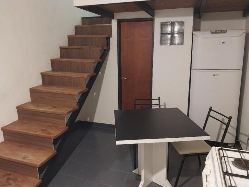 Habitación con escaleras, mesa y nevera. en Espacio km3 en Comodoro Rivadavia