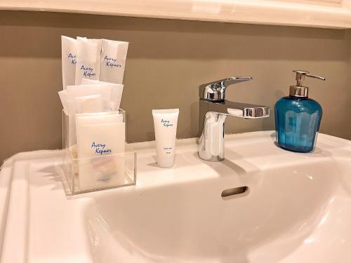 a bathroom sink with a blue soap dispenser on it at Ashley Sabang Jakarta in Jakarta