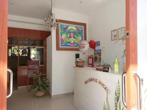 a restaurant with a counter with a painting on the wall at Majestic Mical in Yurimaguas