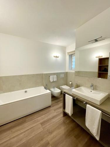 a bathroom with two sinks and a tub and toilet at Guest Martilla Luxury & Garden in Garda