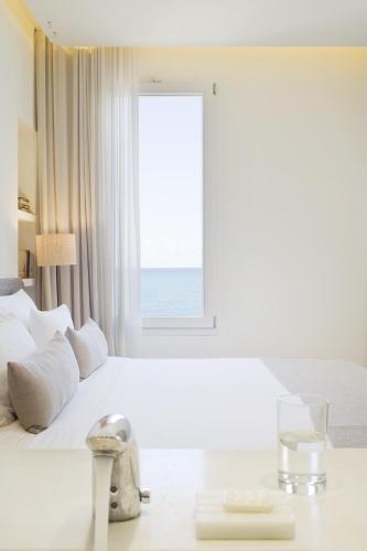 a bedroom with a bed with a view of the ocean at Hostal Empúries in L'Escala