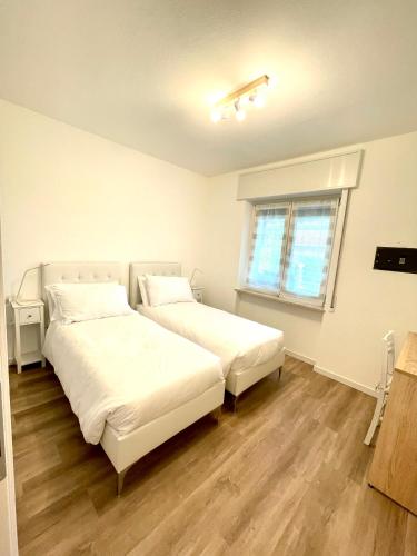 a bedroom with two beds and a window at Guest Martilla Luxury & Garden in Garda